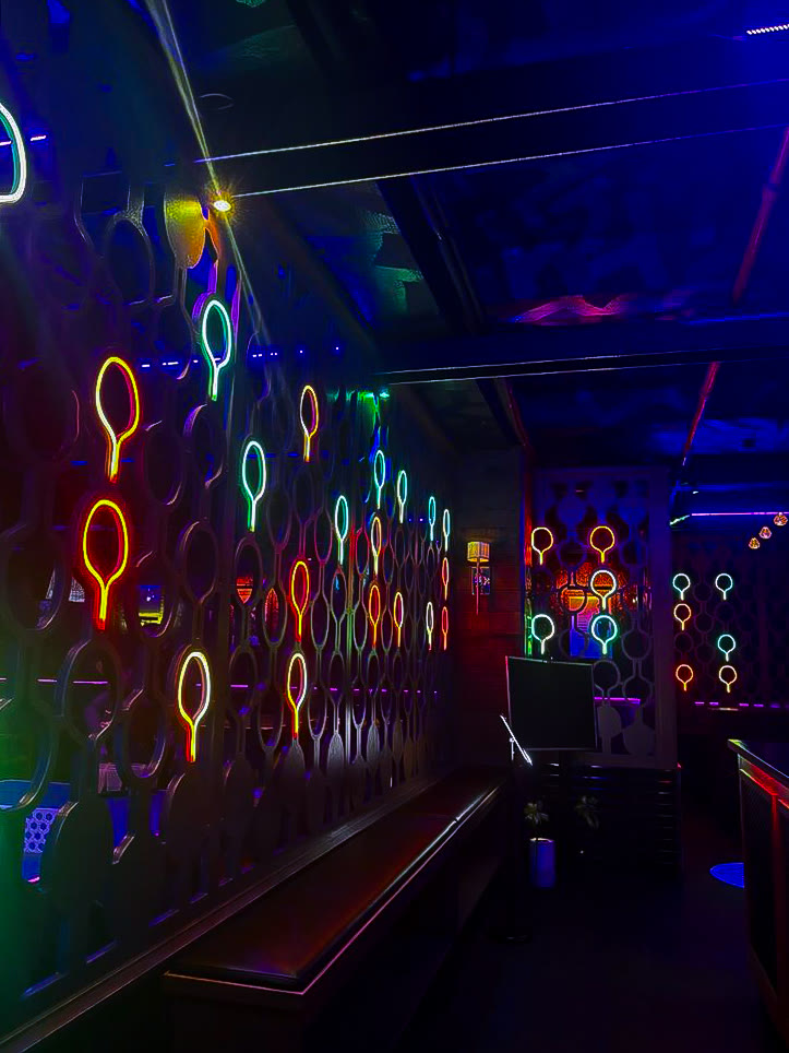 Neon paddle wall inside Space Ping Pong